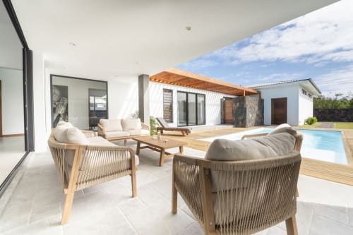 La Villa Boz patio with lounge chairs, wooden deck, pool, and modern white villa in Saint Philbert de Bouaine