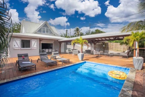 Luxury villa in Fort-de-France with heated saltwater pool, wooden deck, lounge chairs, and tropical garden views