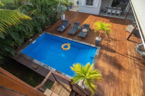 Aerial view of Paradise villa pool deck with blue salt water pool, lounge chairs, wooden decking, and tropical plants in