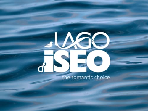 Logo des Lago d'Iseo Ufer-Gästehauses Verdolivo in Sale Marasino mit Wasserwellen-Hintergrund