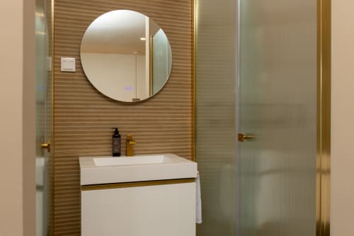 Modern bathroom in Deluxe Double Room at Costa Alentejana, Zambujeira do Mar with round mirror and white sink