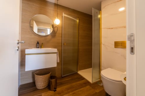 Modern bathroom at Costa Alentejana in Zambujeira do Mar with rainfall shower, white sink, and heated towel rail