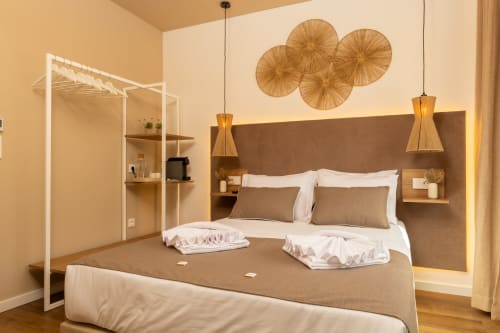 Modern double room at Costa Alentejana B&B in Zambujeira do Mar with brown headboard, pendant lights, and woven wall decor