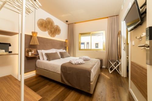 Modern double bedroom at Alojamento Costa Alentejana in Zambujeira do Mar with wooden floors, brown headboard, pendant