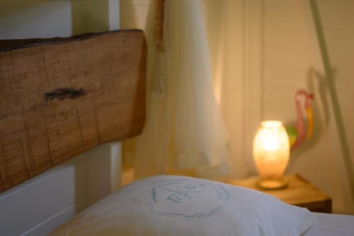 Chambre douillette du gîte Chez Marie et Philippe à Marie-Galante avec lampe de chevet chaleureuse et vue sur le jardin