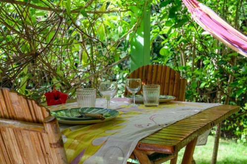 Table de salle à manger en plein air dans le jardin luxuriant du gîte Ti'Kaz Lime, Chez Marie et Philippe, Marie-Galante