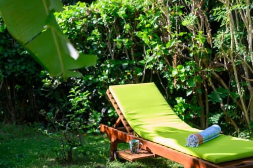 Transat vert citron avec serviette dans le jardin luxuriant de la maison d'hôtes Chez Marie et Philippe, Marie-Galante