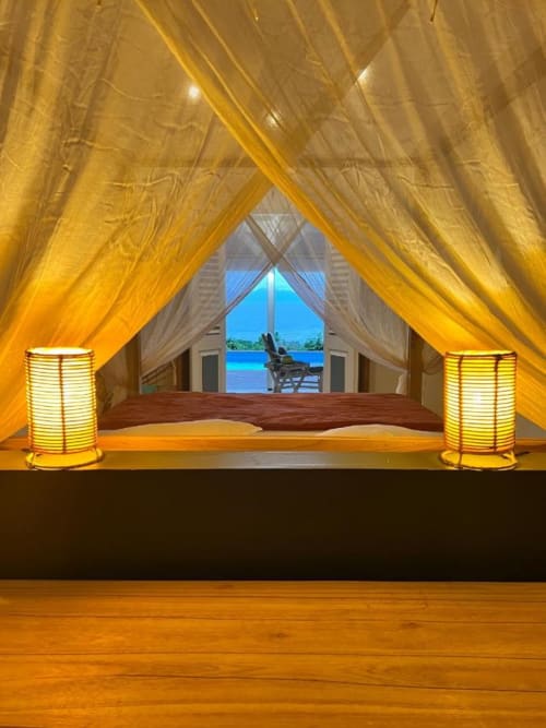 Luxueuse tente-chambre aux draperies dorées, lanternes illuminées et vue sur l'océan chez Chez Marie et Philippe, Marie-Galante