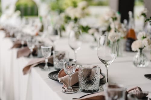 Elegant formal dining table setting at Paradise Location hotel in Fort-de-France with crystal glassware and white floral
