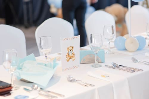 Baby shower table setting at Paradise Location Fort-de-France with teddy bear centerpiece, light blue décor, and formal place