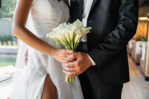 Bride and groom holding white calla lily bouquet at Paradise Location wedding in Fort-de-France