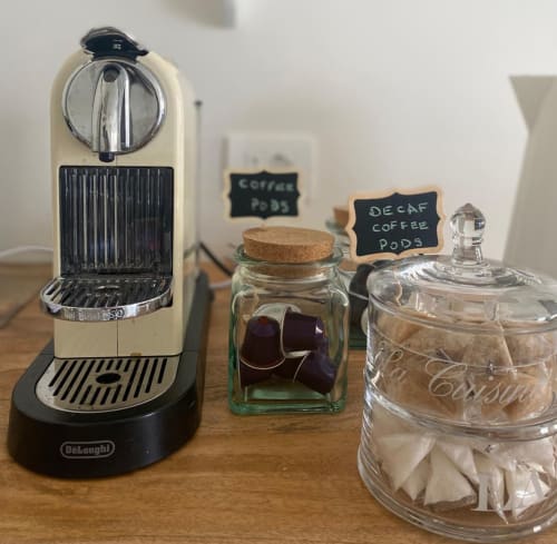 Verdolivo coffee station with DeLonghi machine, coffee pods, and sugar at Sale Marasino B&B