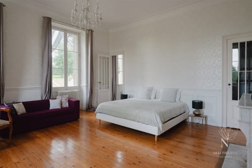 Vue d'ensemble de la suite, avec un lit king size, un canapé convertible et une décoration vintage 