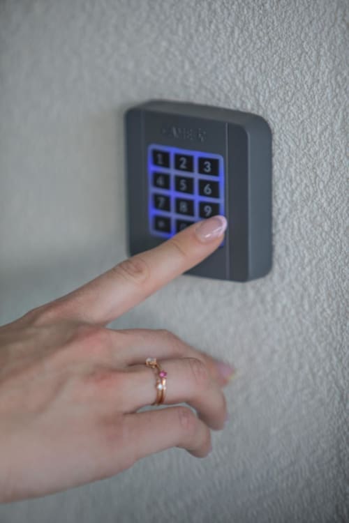 Guest entering access code on keypad at Verdolivo bed and breakfast in Sale Marasino, Italy