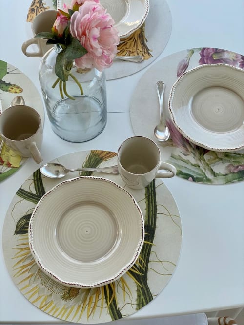 Elegant table setting at Verdolivo B&B with floral placemats, textured dinnerware, and fresh pink peonies
