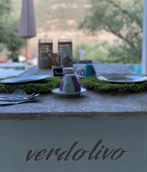 Outdoor dining setup at Verdolivo B&B in Sale Marasino with place settings, moss runner, and lakeside views