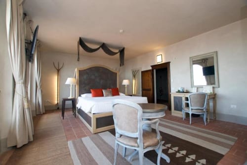 Spacious Junior Suite at Hotel San Giovanni Resort in Saluzzo with elegant bedroom, sitting area, and mountain views