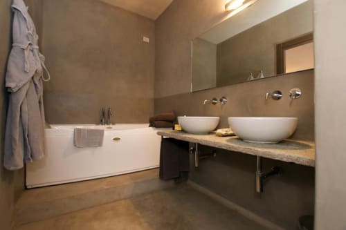 Modern bathroom in Hotel San Giovanni Resort Junior Suite with dual vessel sinks, bathtub, and mountain view from Saluzzo.