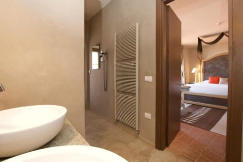 Spa-style bathroom in Hotel San Giovanni Resort Junior Suite with soaking tub, walk-in shower, heated towel rack, and