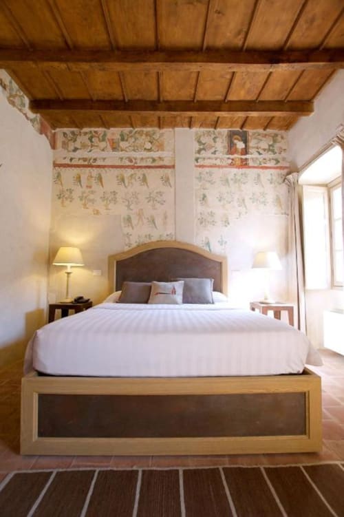 Deluxe bedroom at Hotel San Giovanni Resort in Saluzzo with wooden beams, white linens, and garden view