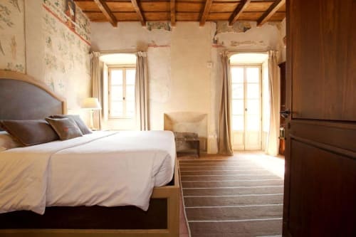 Deluxe room at Hotel San Giovanni Resort in Saluzzo with garden view, wooden beams, elegant bed, and terrace doors