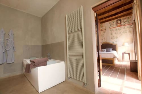 Deluxe Room bathroom at Hotel San Giovanni Resort with soaking tub, heated towel rail, and adjoining bedroom view