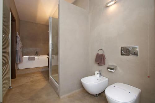 Modern bathroom in Hotel San Giovanni Resort Junior Suite, Saluzzo, featuring white bidet and toilet with beige tiles
