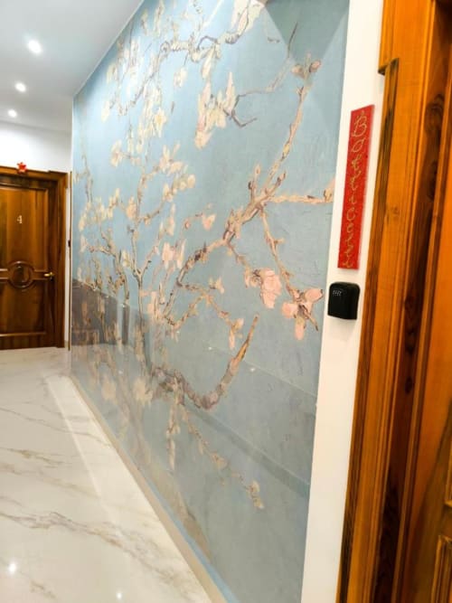 Corridoio dell'Hotel I Migliori Artisti di Napoli con murale blu alle pareti, porte in legno e pavimento in marmo