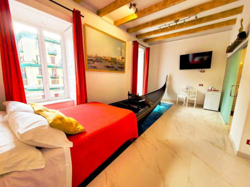Camera a tema gondola veneziana presso I Migliori Artisti a Napoli con letto rosso e travi in legno