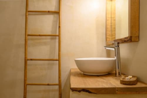 Lavabo moderne avec vasque en céramique blanche, robinetterie chromée et rangement en échelle bois à la villa Ti'Kaz Vanille en Guadeloupe