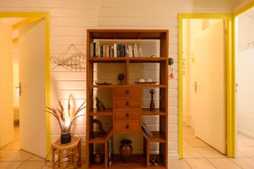 Intérieur élégant de villa chez Marie et Philippe avec portes jaune vif, étagères en bois garnies de livres et accessoires de décoration