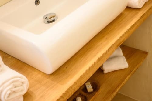 Vasque en céramique blanche et plan de toilette en bois à la villa Ti'Kaz Vanille, Chez Marie et Philippe