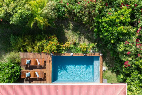 Vue aérienne de la piscine privée de la villa Ti'Kaz Vanille entourée de luxuriants jardins tropicaux chez Marie et Philippe,