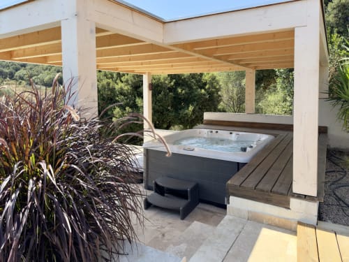 Pergola en bois abritant le bain à remous de l'hôtel SoleMare à Alata, avec vue sur le jardin