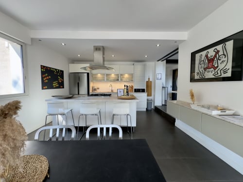 Cuisine ouverte contemporaine et salle à manger à SoleMare à Alata : mobilier blanc, îlot, art actuel
