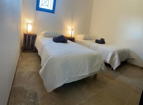 Twin beds with white linens in bright bedroom at Mas St André cottage, Provence