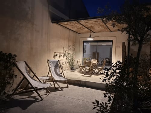 Provence cottage patio with deckchairs, dining area, and pergola at night, Mas St André gîte
