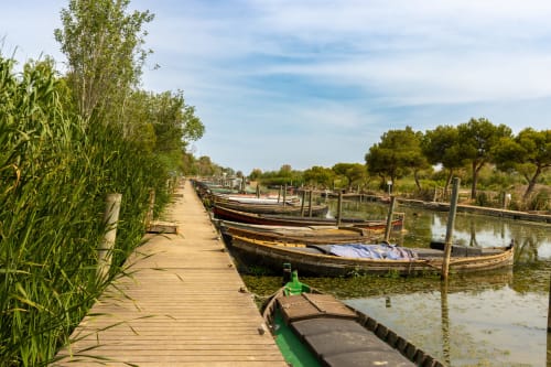Bateaux en bois traditionnels amarrés le long d'un quai en bois à Mas St André, une charmante retraite champêtre à Saint-Andiol, France.