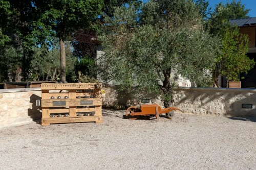 Structures de jeu en bois et camion jouet vintage dans la cour en gravier du Mas St André, chambre d'hôtes en Provence à Saint-Andiol