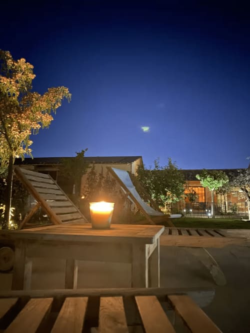 Mas St André courtyard at dusk with illuminated lantern and wooden pergola, Saint-Andiol