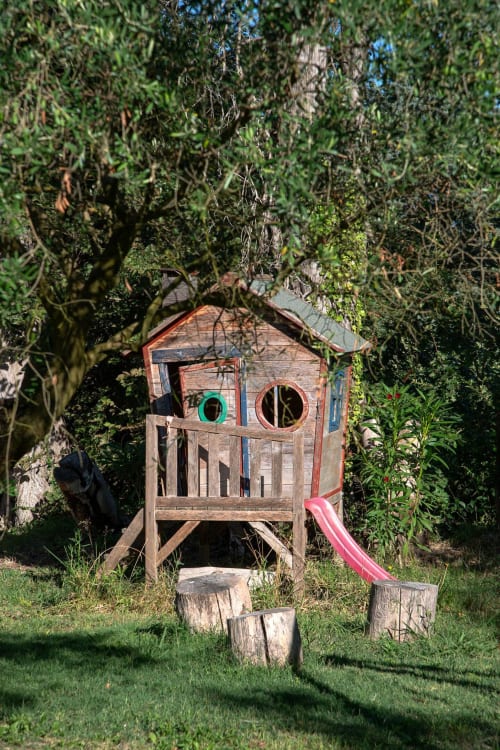 Rustic wooden playhouse with pink slide at Mas St André bed and breakfast in Saint-Andiol, France