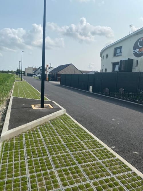 Cosyade hotel exterior in Bourbourg with permeable paving, black fence, and modern round building entrance