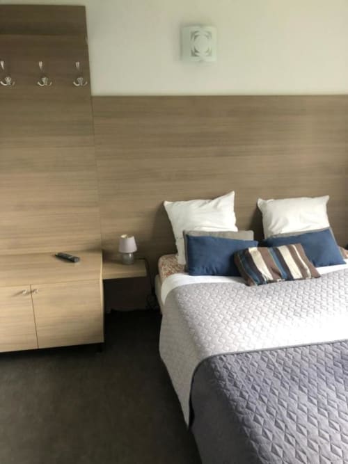 Chambre Double Économique à l'Hôtel Cosyade à Bourbourg avec lit, oreillers blancs, coussins rayés, mobilier en bois