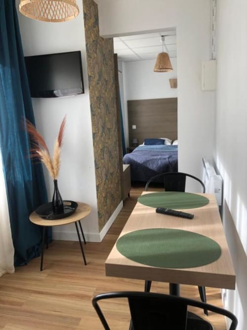 Studio Supérieur à Cosyade à Bourbourg avec table à manger, kitchenette, TV et vue sur la chambre