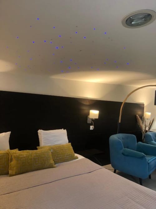 Modern Family Studio at Cosyade hotel in Bourbourg with bed, blue armchair, and ceiling lights