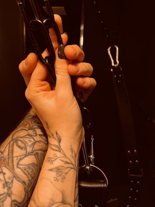 Tattooed hand holding black carabiners at Love Room apartment in Vannes, France
