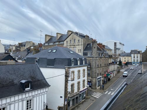 Historic Vannes cityscape with slate-roofed buildings, street with pedestrians and cars, view from Love Room apartment
