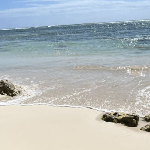 Plage de sable blanc immaculée aux eaux turquoise et affleurements rocheux à Chez Marie et Philippe, Marie-Galante