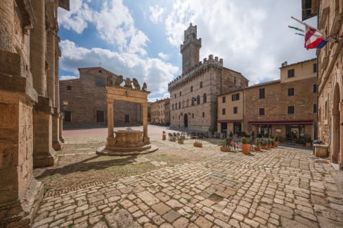 Medieval Piazza Grande in Arezzo with historic stone buildings, tower, and well, perfect for Cognaia Loft guests exploring
