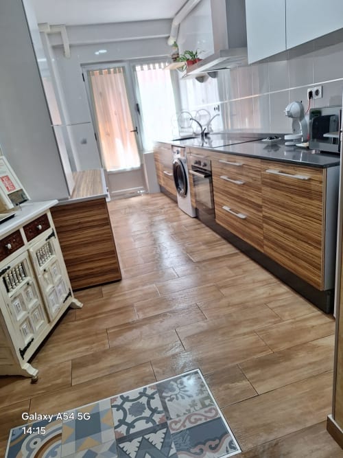 Modern kitchen in Benavente tourist apartment with wood cabinets, black countertops, stainless appliances